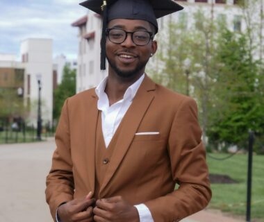 smiling black man in glasses and mortarboard